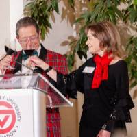 Jim and Donna Brooks speaking to crowd at podium and giving a toast